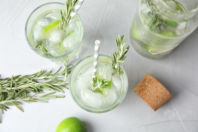 Photo of Flat lay composition with lime and rosemary cocktail on gray table