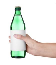 Photo of Woman holding glass bottle with soda water on white background, closeup