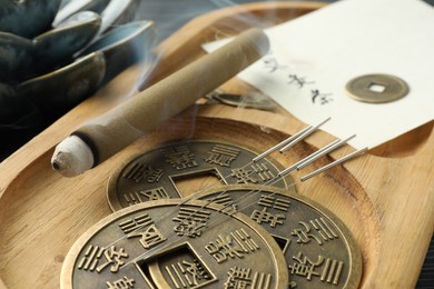 Photo of Acupuncture needles, moxa stick and antique Chinese coins on wooden tray, closeup