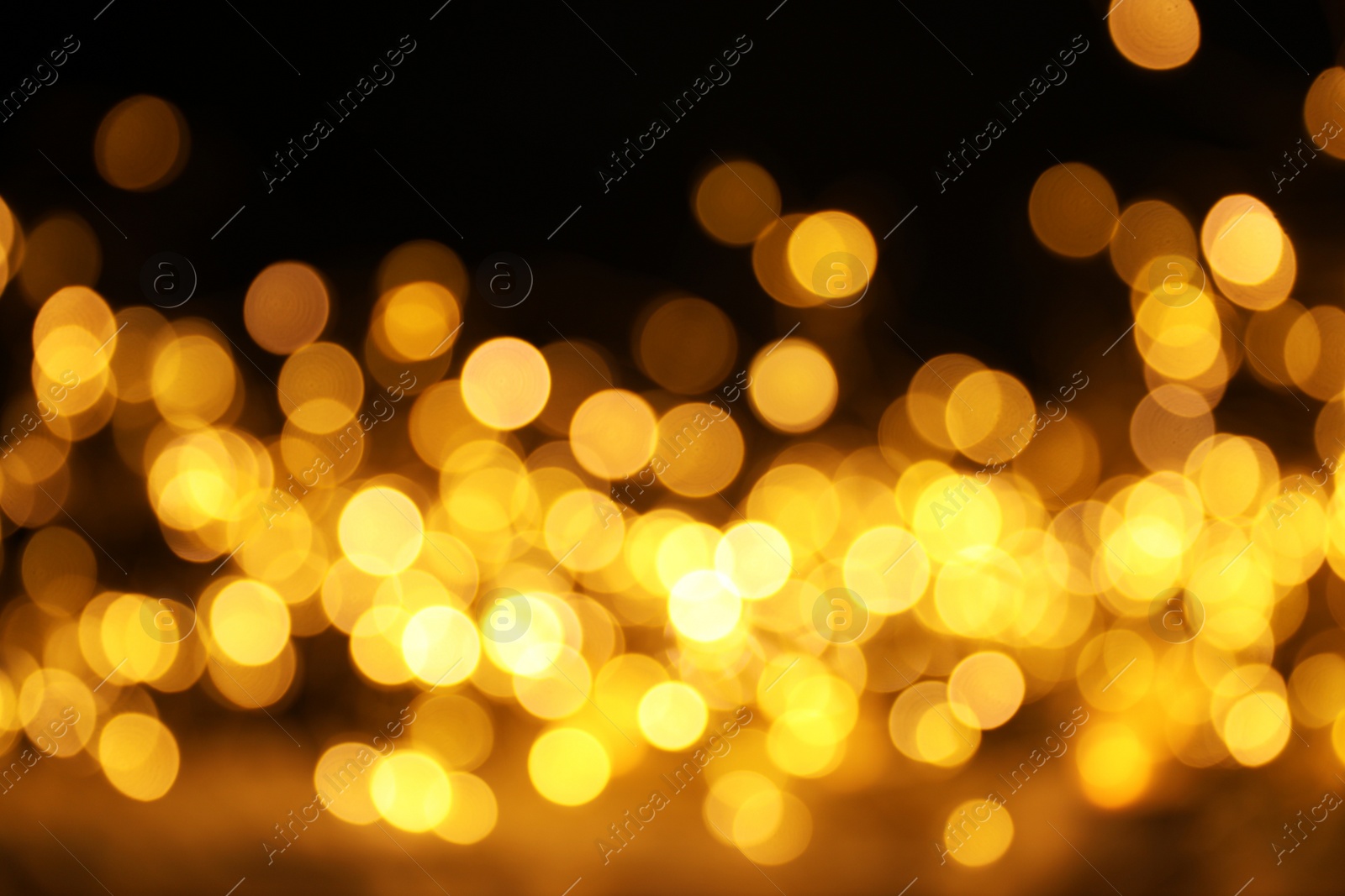 Photo of Gold glitter with bokeh effect on dark background