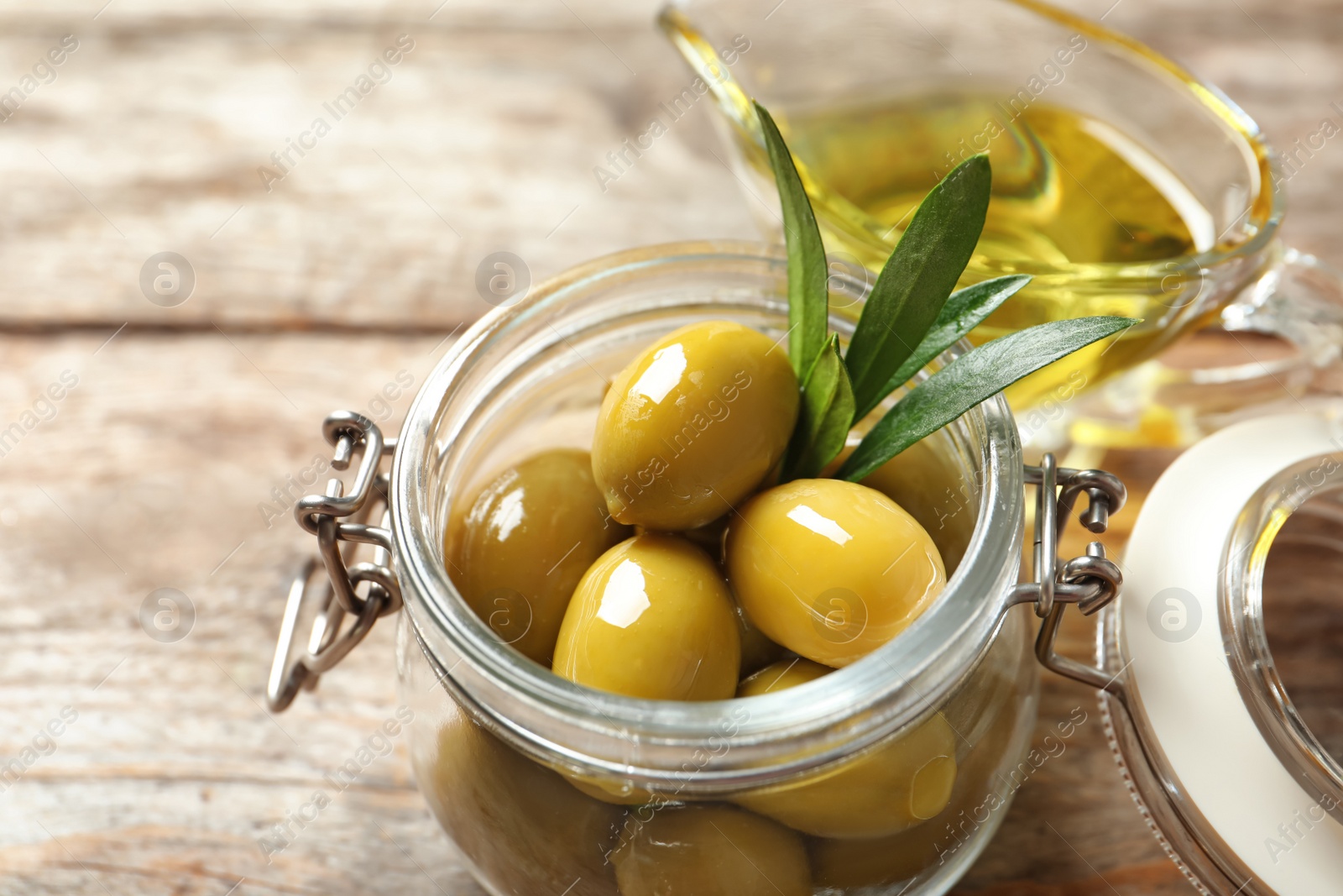 Photo of Ripe olives covered with oil in jar, closeup