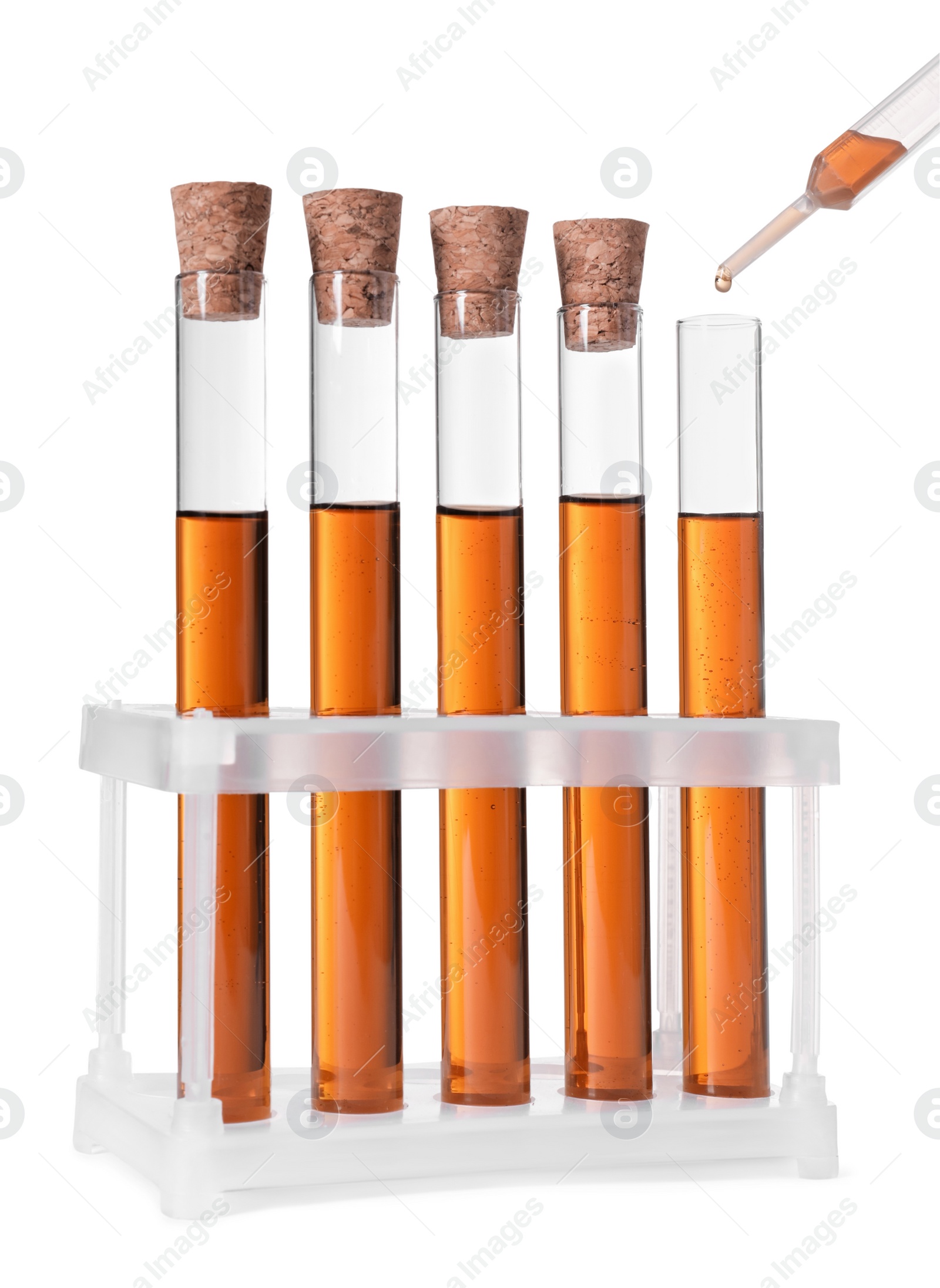 Photo of Dripping brown liquid from pipette into test tube on white background