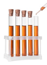 Dripping brown liquid from pipette into test tube on white background