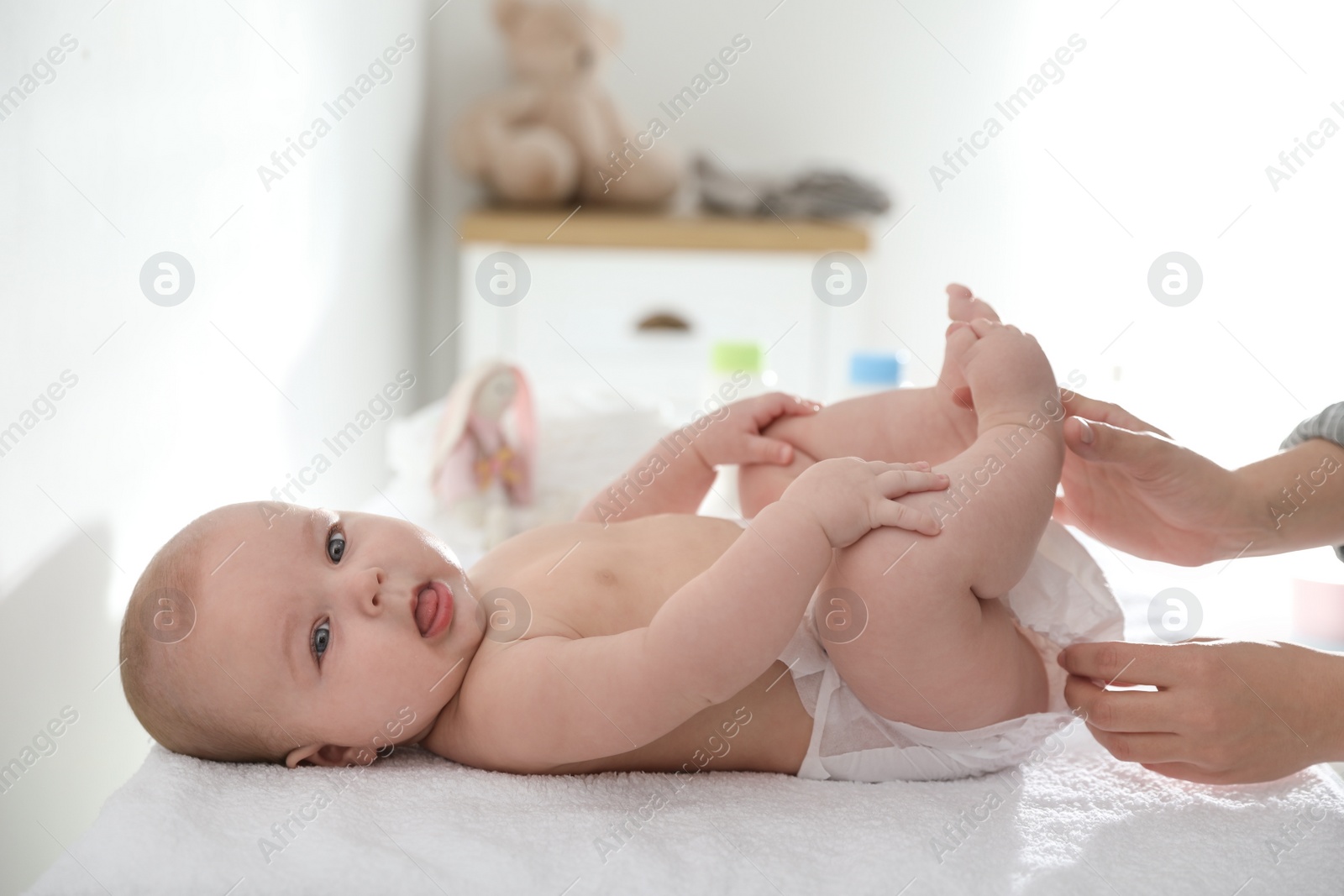 Photo of Mother changing her baby's diaper on table
