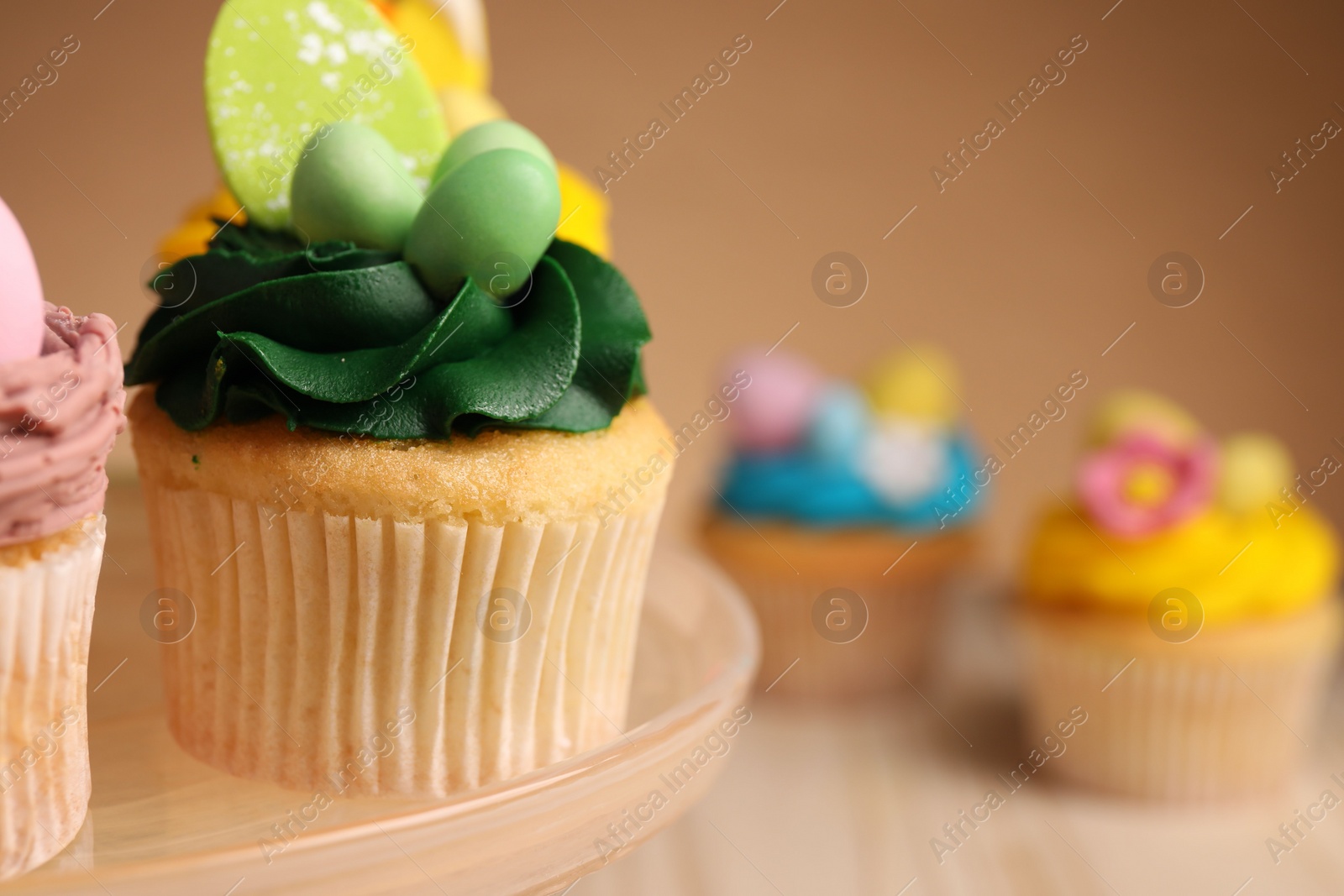 Photo of Tasty cupcakes with Easter decor on table, closeup. Space for text