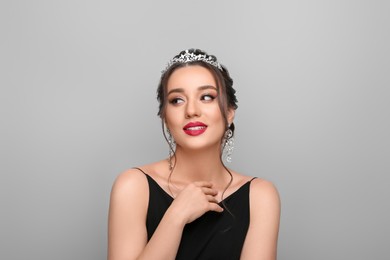 Photo of Beautiful young woman wearing luxurious tiara on light grey background