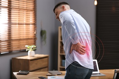 Image of Man suffering from back pain in office. Symptom of poor posture