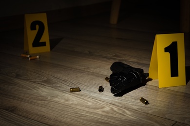 Photo of Gun and shell casings on wooden floor at crime scene