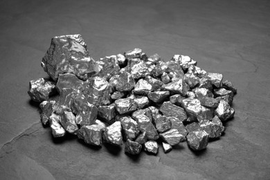 Photo of Pile of silver nuggets on black table