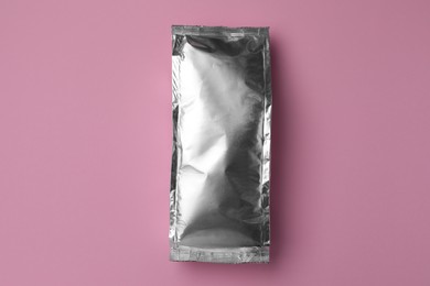 Photo of Blank foil package on pink background, top view