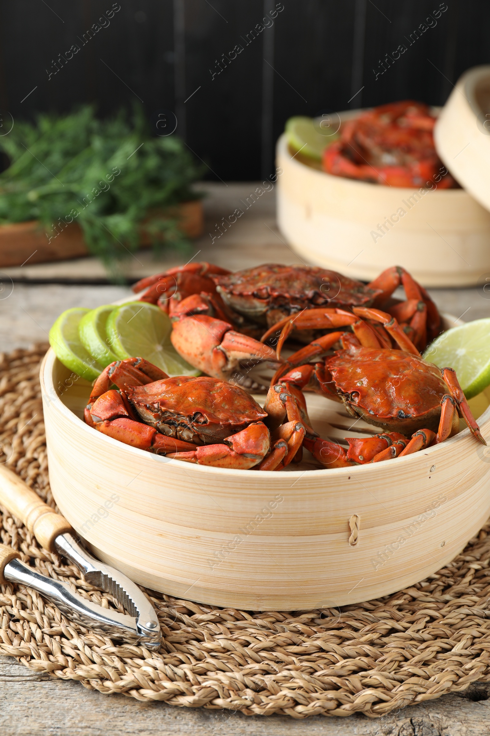 Photo of Delicious boiled crabs with lime and dill served on wooden table