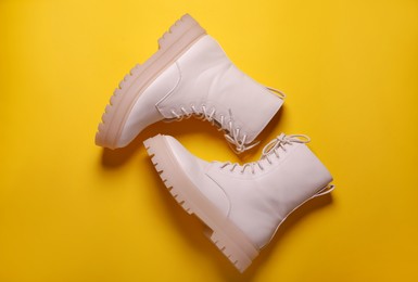 Pair of stylish shoes on yellow background, flat lay