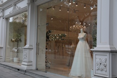 Showcase with beautiful wedding dress on mannequin