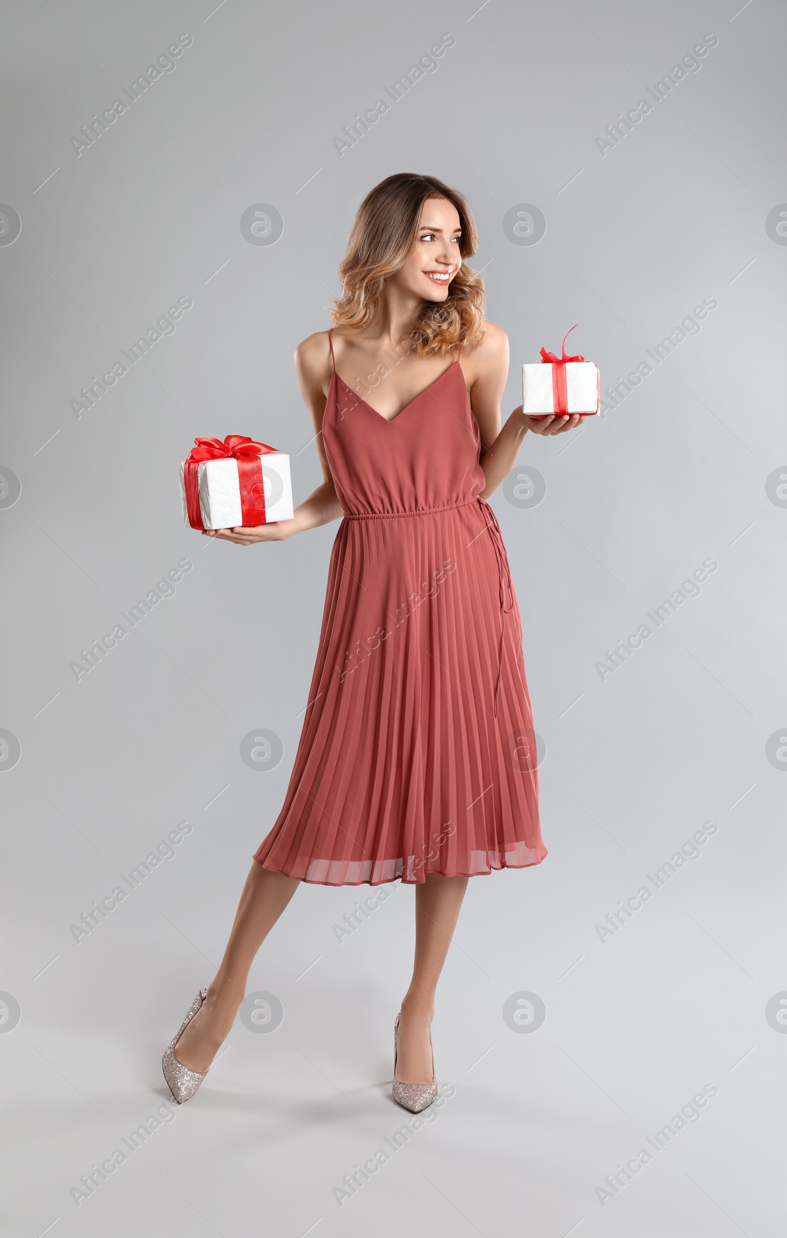 Photo of Beautiful young woman with Christmas presents on light grey background