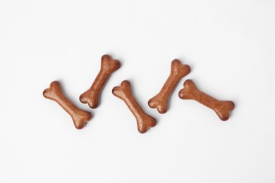 Photo of Bone shaped dog cookies on white background, flat lay