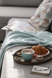 Photo of Tray with tasty breakfast on grey sofa in morning.  Space for text
