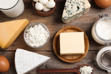 Different dairy products on wooden table, flat lay