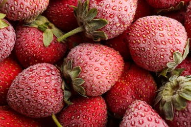 Tasty frozen strawberries as background, top view