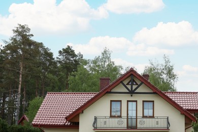 Photo of Modern building with red roof outdoors on spring day