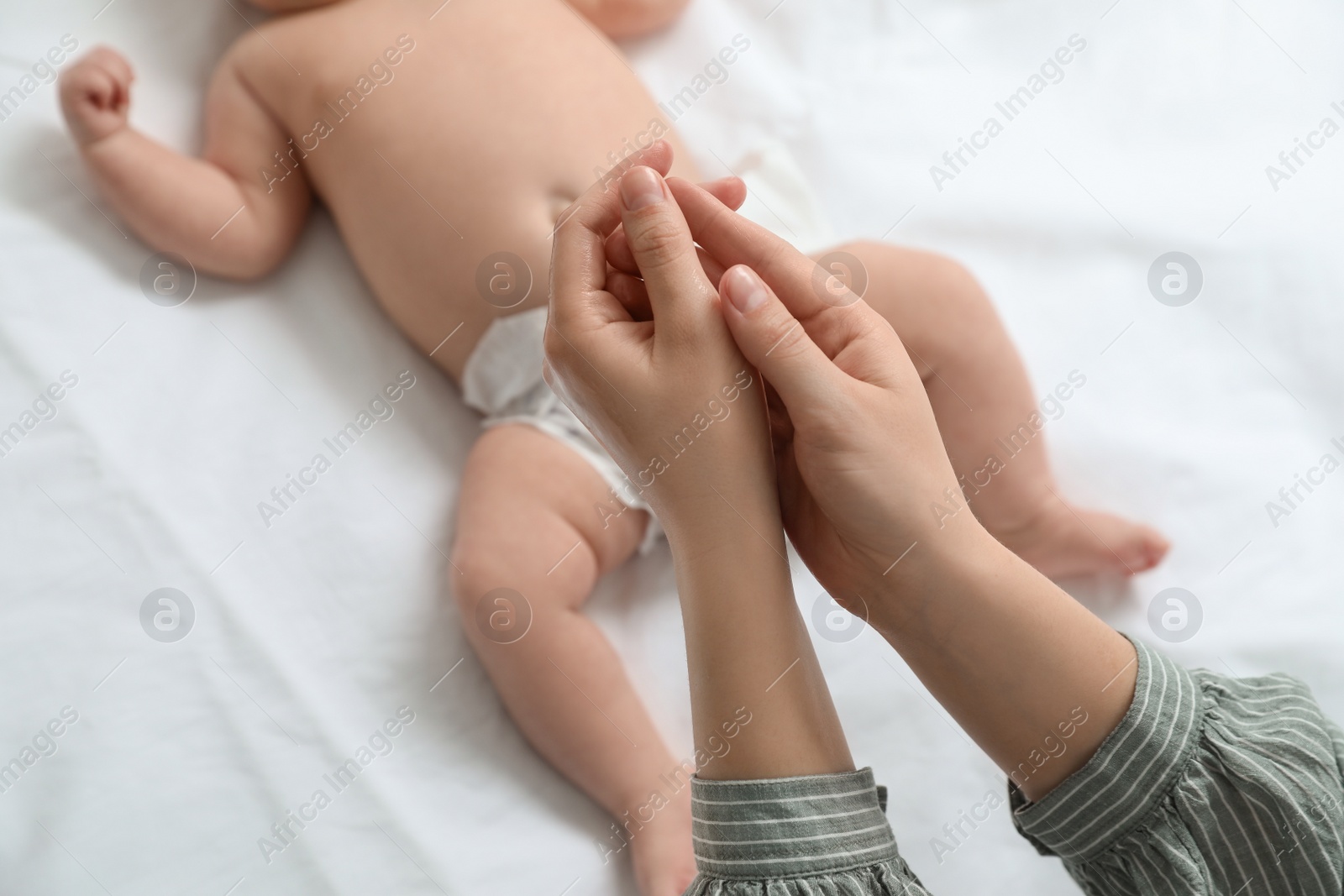 Photo of Mother with massaging oil near her baby, closeup