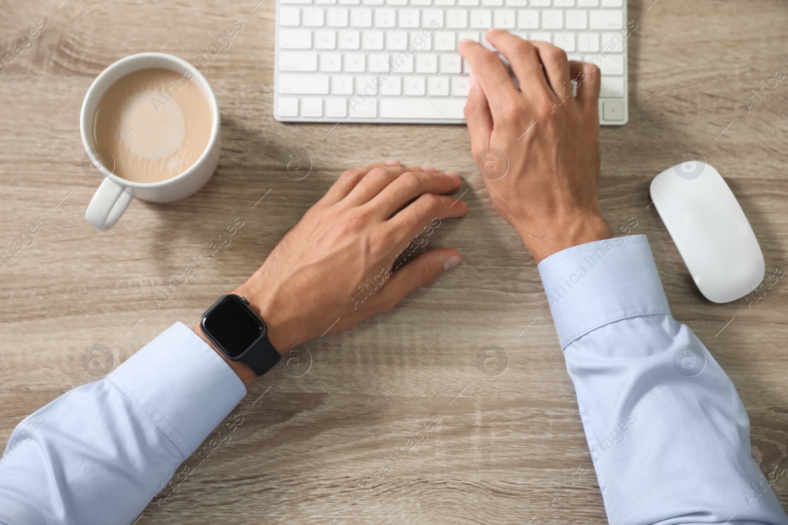 Image of Man with stylish smart watch working at wooden table, top view