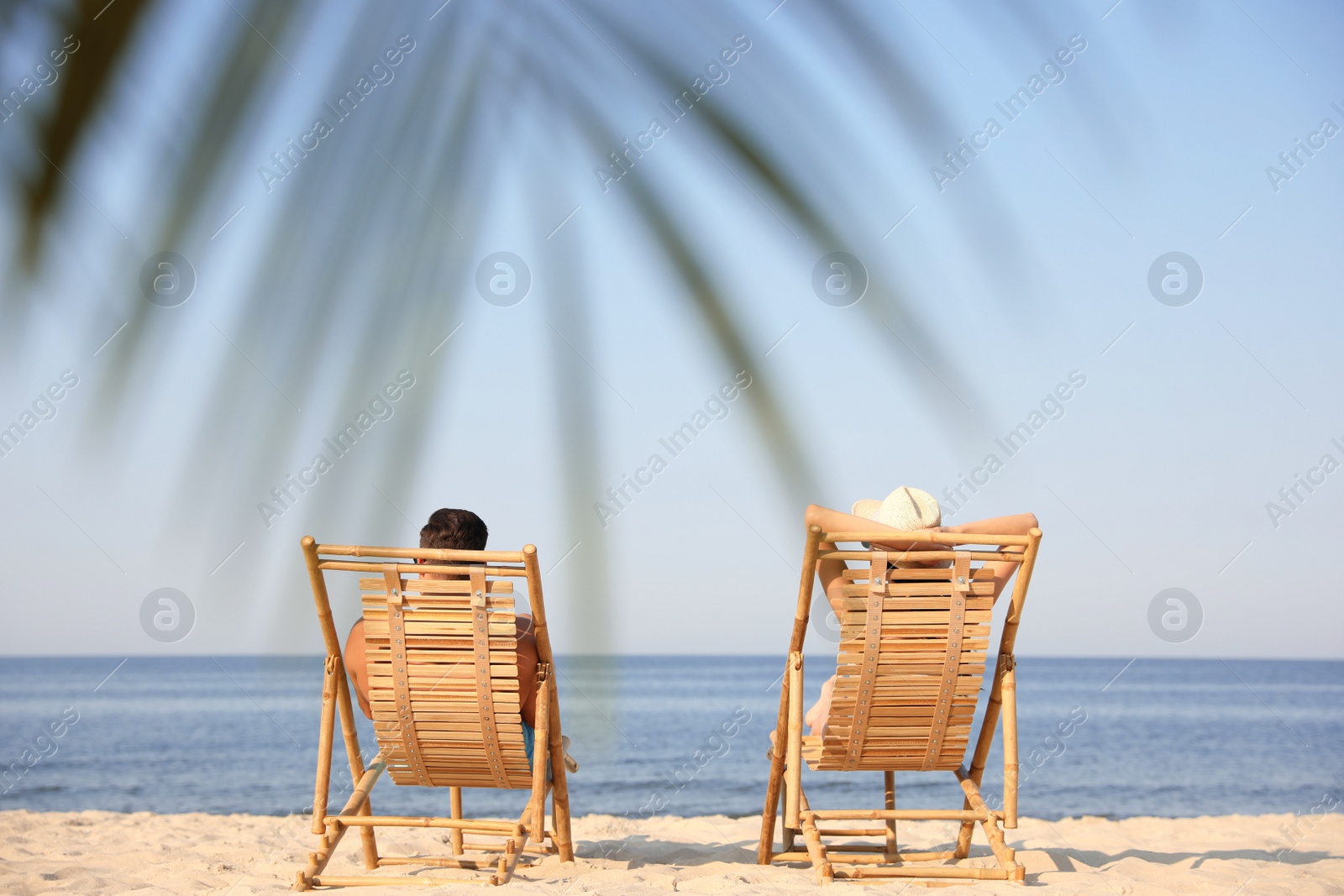 Photo of Couple resting on sunny beach at resort