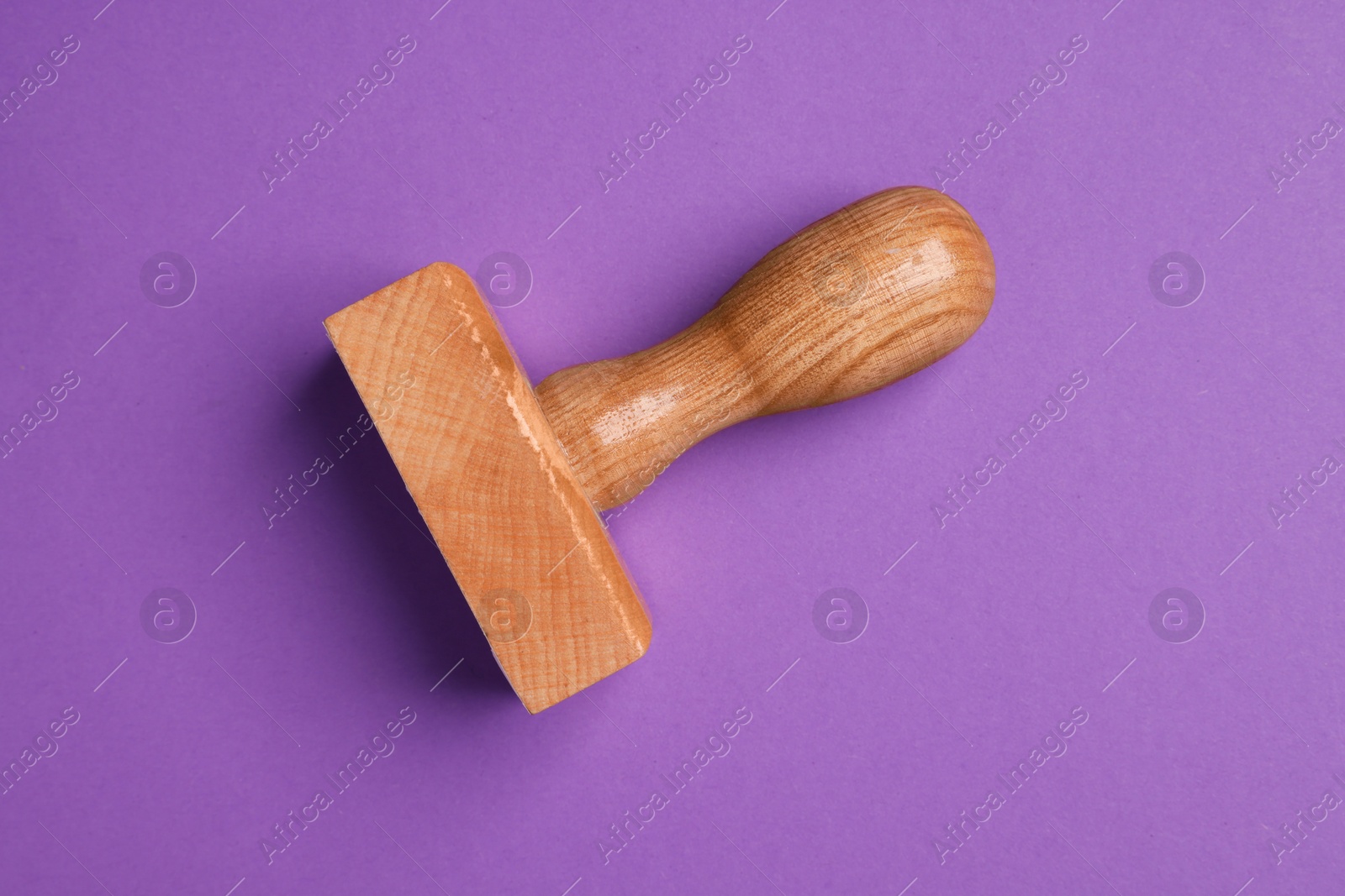 Photo of One wooden stamp tool on purple background, top view