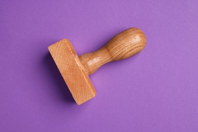 Photo of One wooden stamp tool on purple background, top view