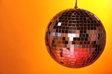 Photo of Shiny disco ball on color background, space for text