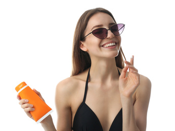 Photo of Young woman applying sun protection cream on white background