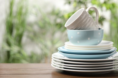 Beautiful ceramic dishware and cup on wooden table outdoors, space for text