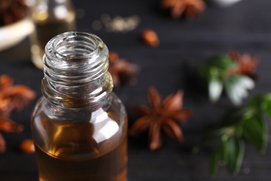 Photo of Anise essential oil in bottle on table, closeup. Space for text