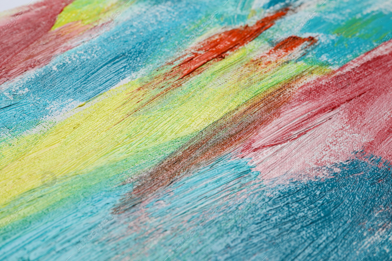 Photo of Strokes of colorful acrylic paints on canvas, closeup