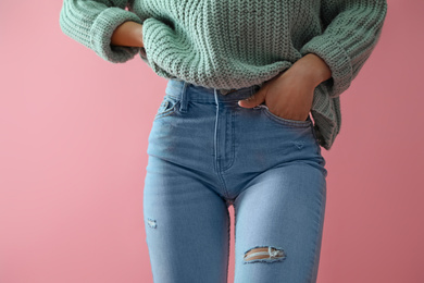Woman wearing jeans on pink background, closeup