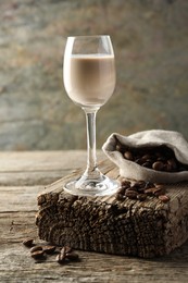 Coffee cream liqueur in glass and beans on wooden table