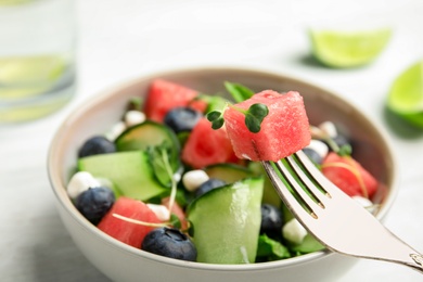 Photo of Delicious salad with watermelon served in bowl, closeup