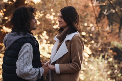 Photo of Happy young couple spending time together in autumn park, space for text. Dating agency