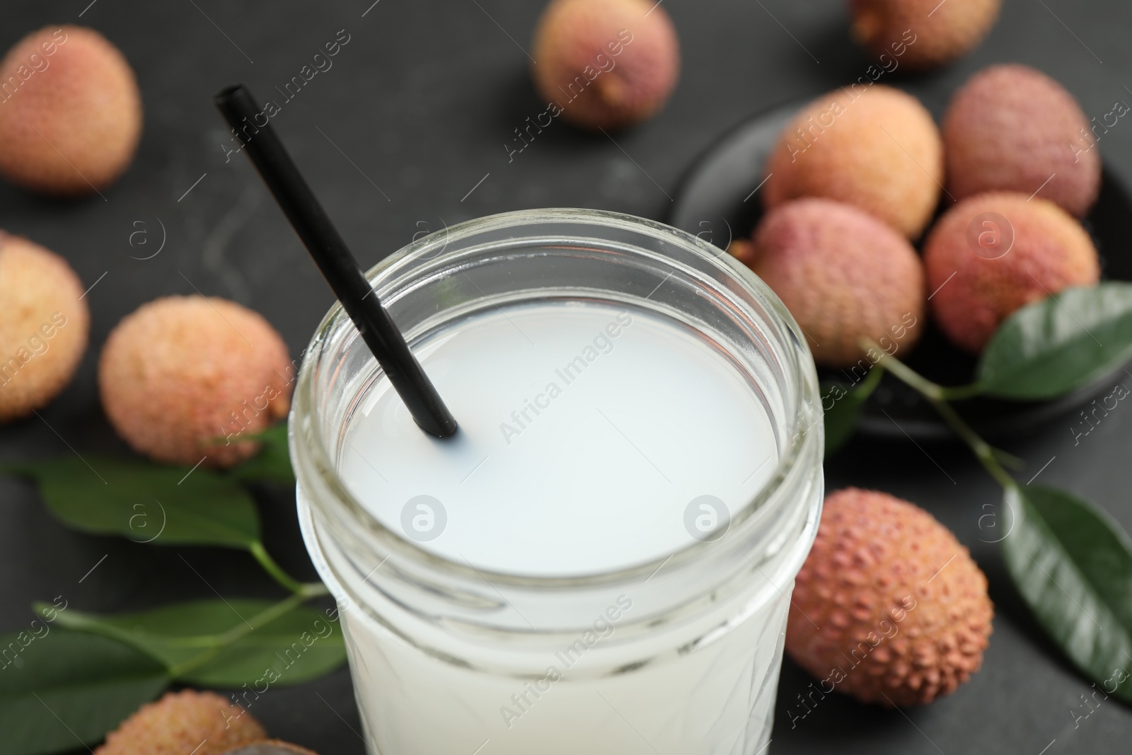 Photo of Freshly made lychee juice on grey table, closeup