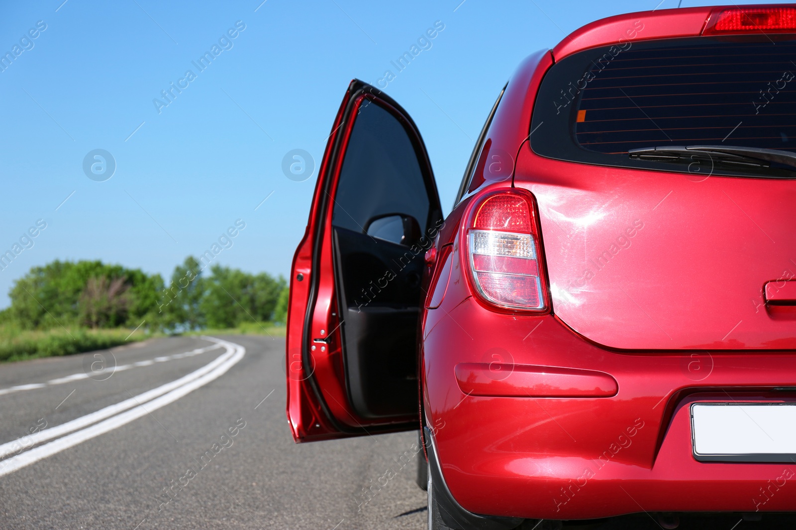 Photo of Modern color family car with open door on highway