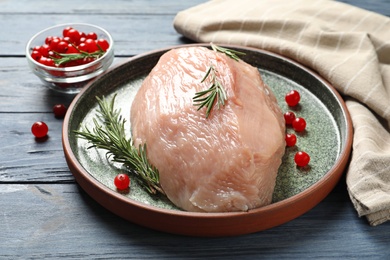 Plate with raw turkey fillet and ingredients on wooden background