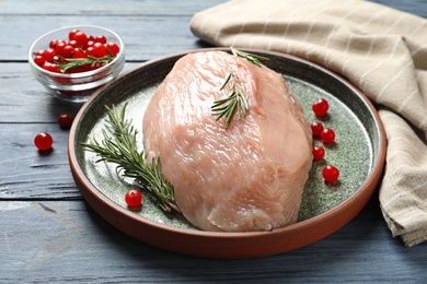 Photo of Plate with raw turkey fillet and ingredients on wooden background