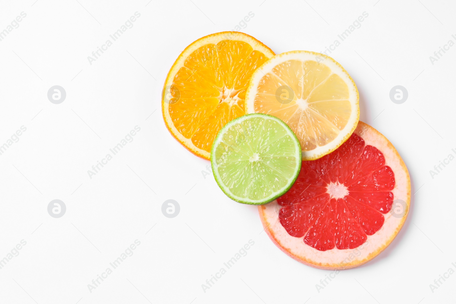 Photo of Slices of fresh ripe citrus fruits on white background, flat lay. Space for text