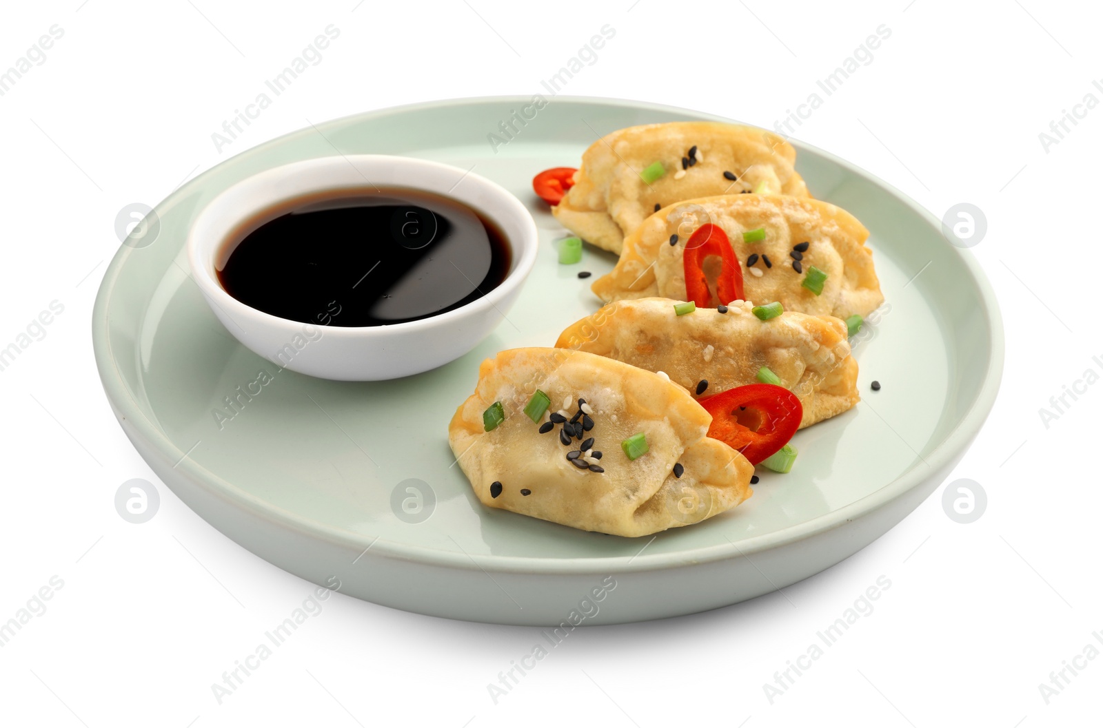 Photo of Delicious gyoza (asian dumplings) with soy sauce, pepper, onion and sesame isolated on white