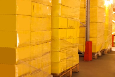 Photo of Warehouse with stacks of boxes on wooden pallets. Wholesaling