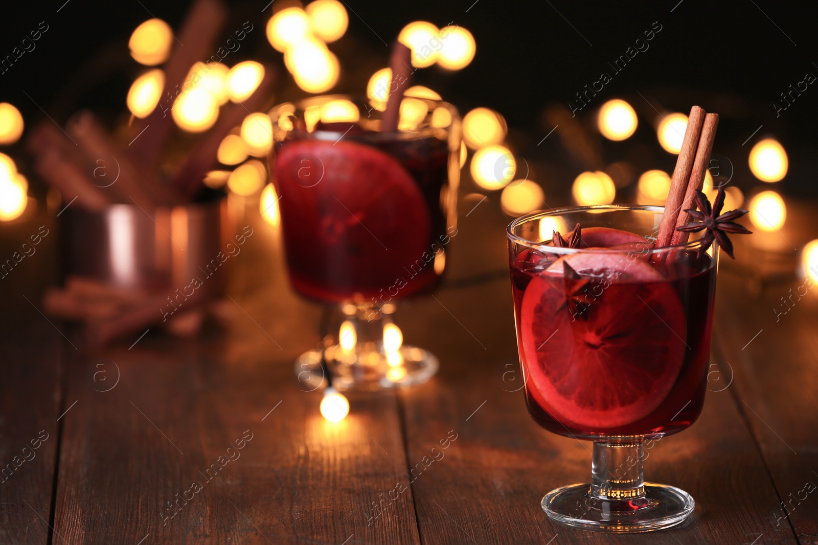 Photo of Mulled wine with cinnamon, anise and orange in glass on table. Space for text