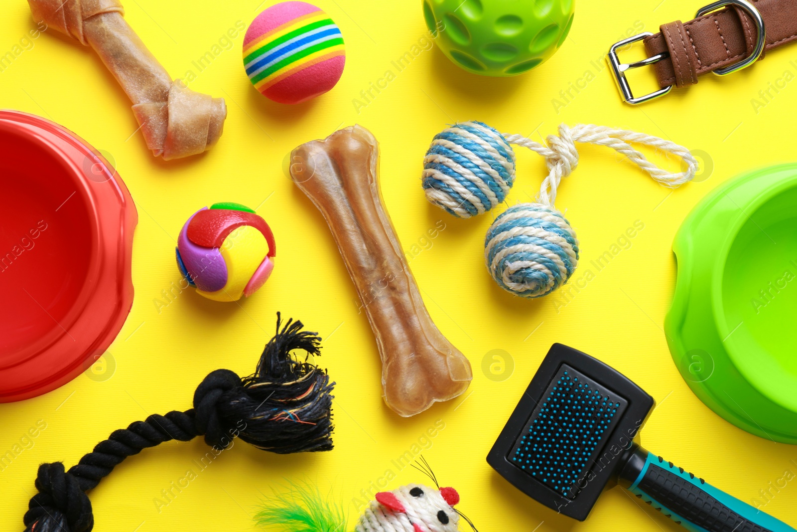 Photo of Flat lay composition with pet toys and feeding bowls on yellow background