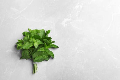 Bunch of fresh mint on grey marble  background, top view. Space for text