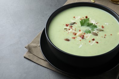 Photo of Bowl of delicious asparagus soup on dark table, space for text