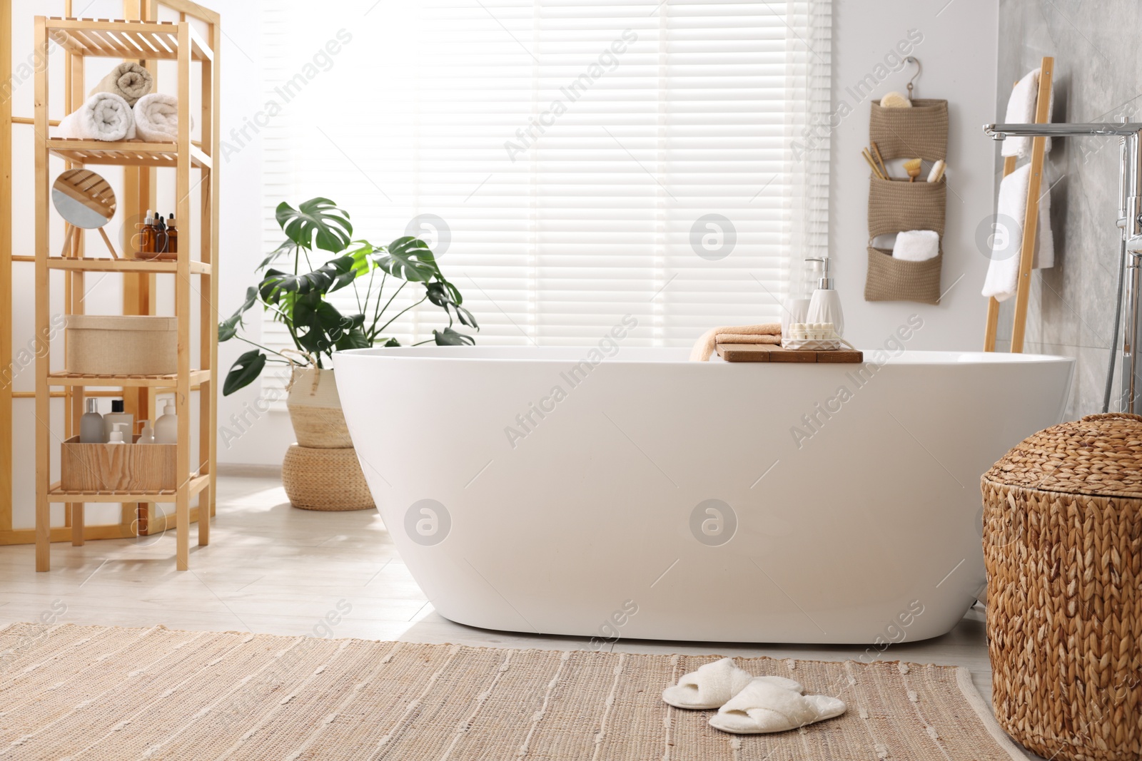 Photo of Set of different bath accessories and soap on tub in bathroom