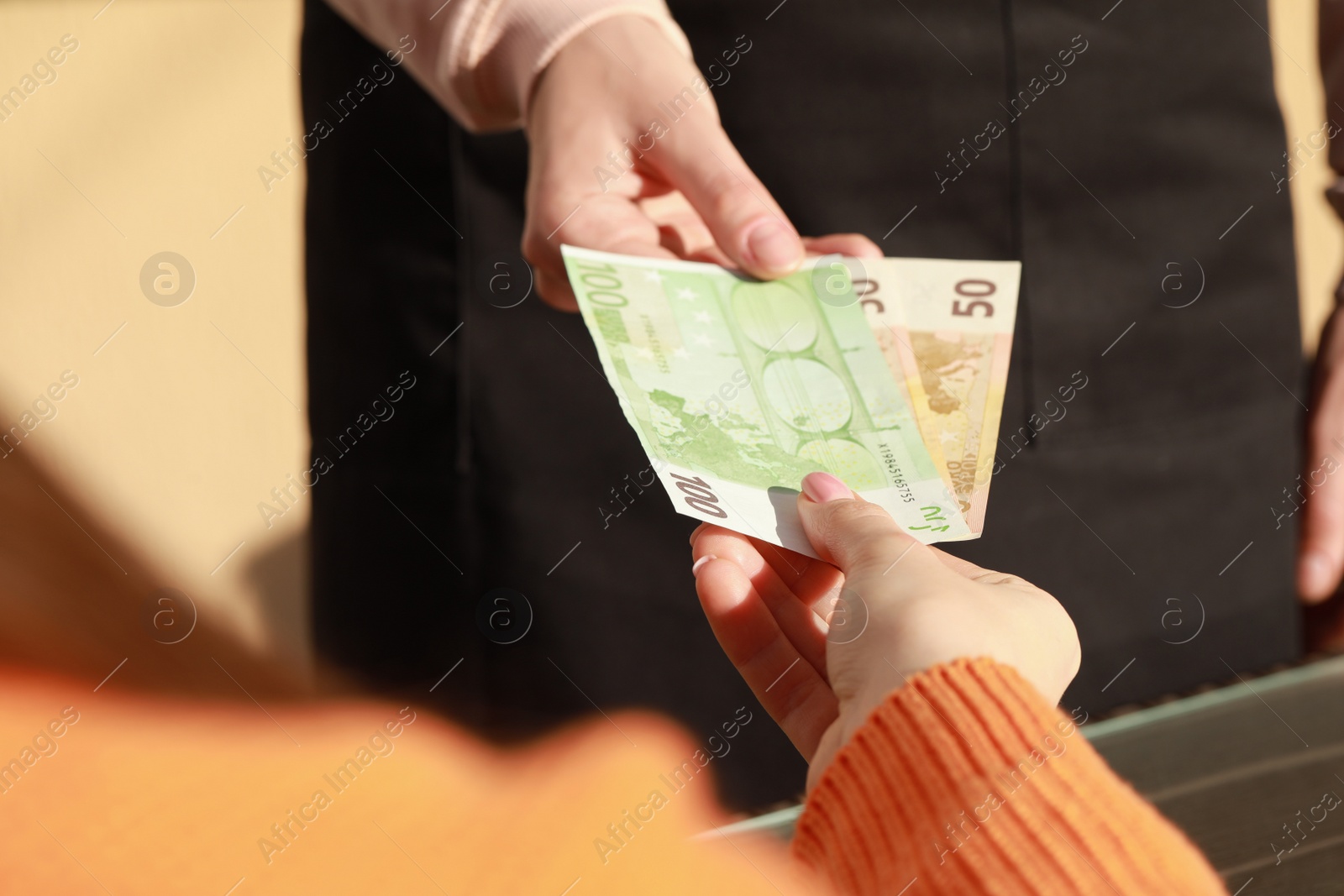 Photo of Woman paying for order to waitress at outdoor cafe, closeup. Leave tip